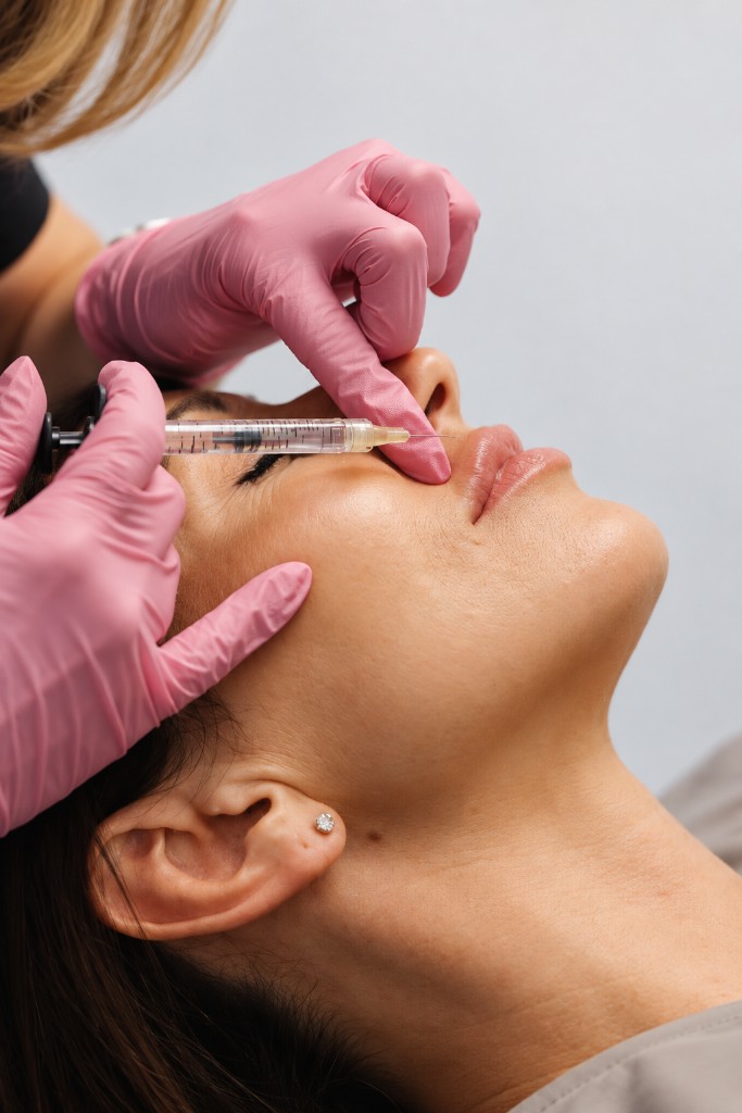 Pink gloves with a syringe at the nose