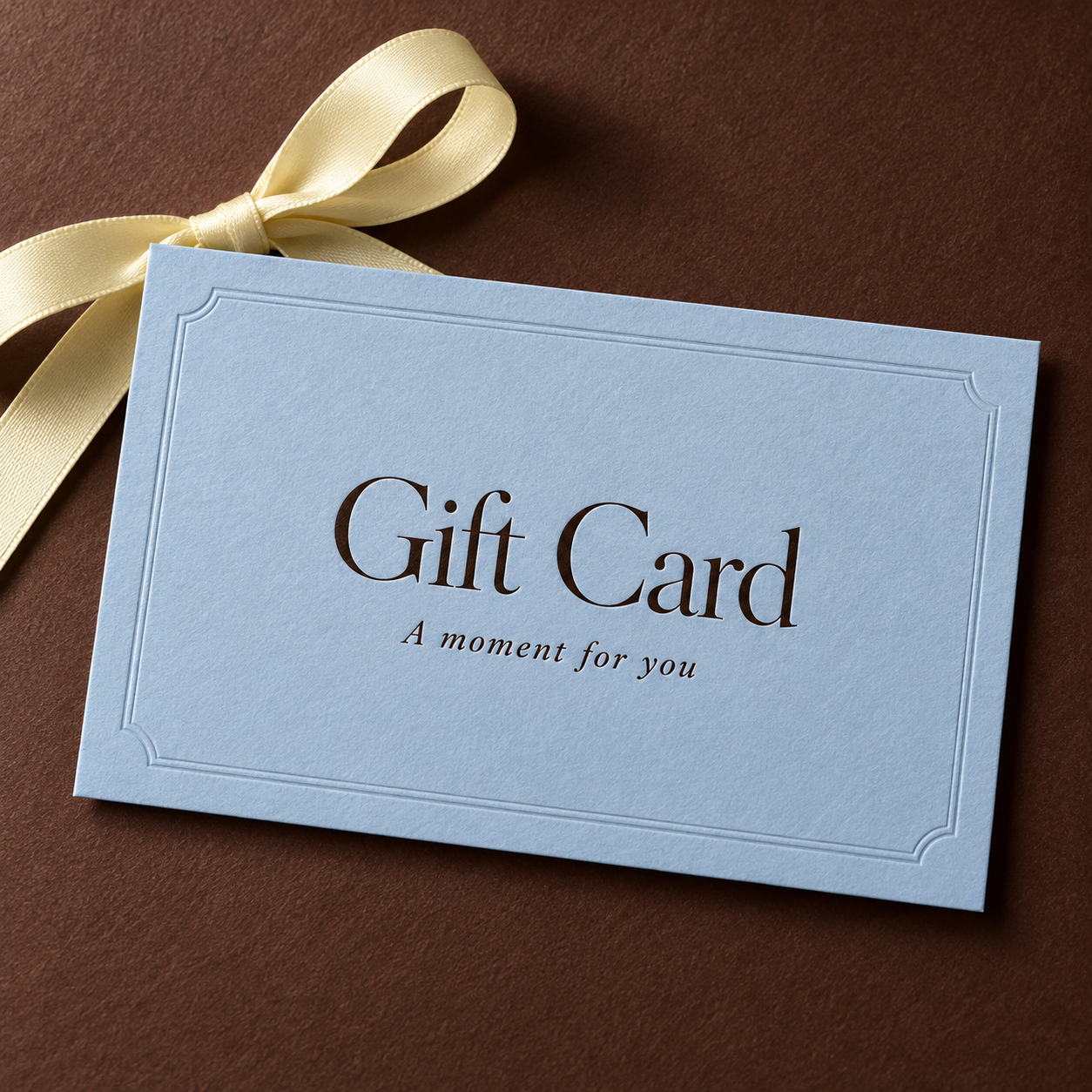 Blue gift card with a ribbon, reading Gift Card, A moment for you