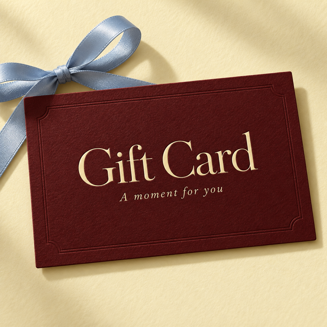 Burgundy gift card with a ribbon, reading Gift Card, A moment for you
